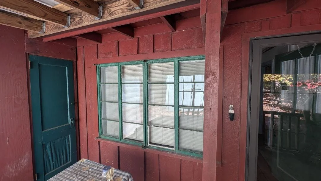 Stonehaus porch before renovation, with red siding and green window frames