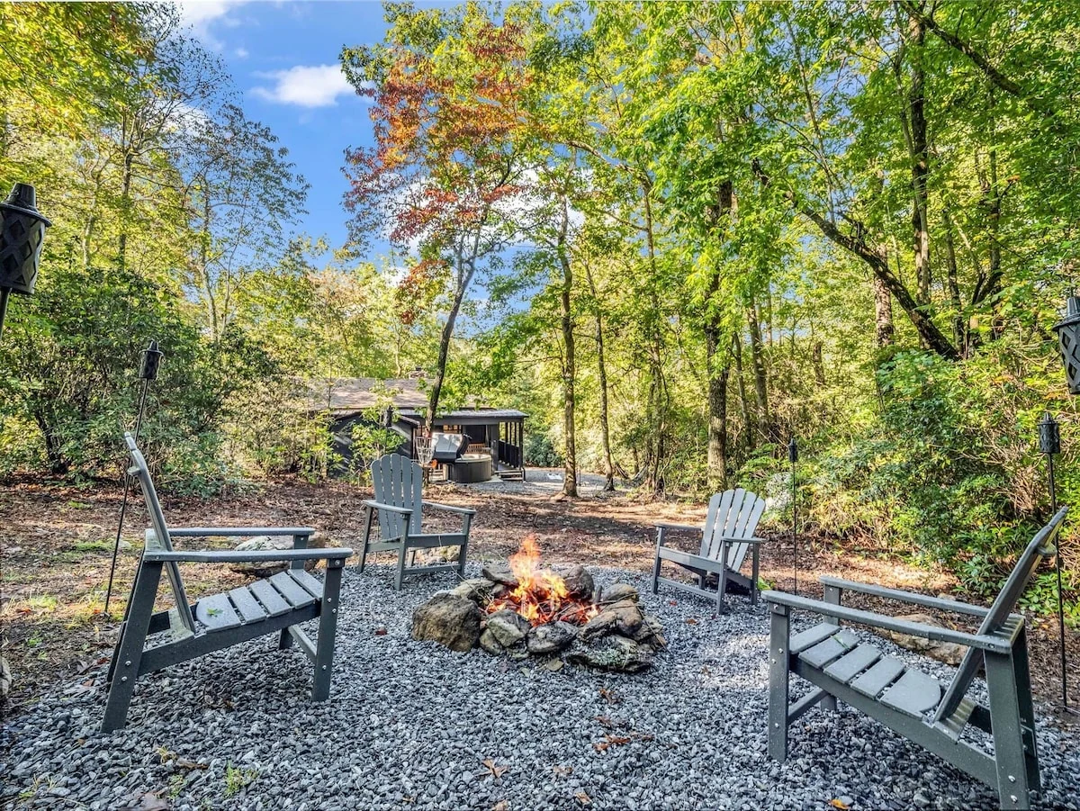 Stonehaus fire pit surrounded by outdoor chairs in its wooded garden
